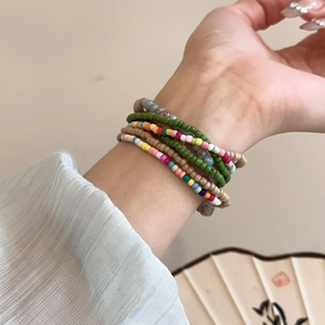 Detail of colorful Bohemian seed bead bracelets stacked on wrist for a layered vintage look