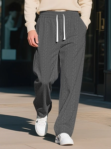 Detailansicht der dunkelgrauen Strickhose mit weißem Kordelzug und Zopfmuster-Struktur