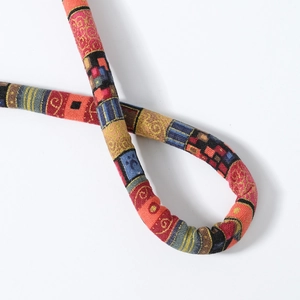 Detail of bohemian ethnic braided hair tie with colorful geometric woven patterns