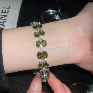 Detailed view of silver double-layered bracelet with green zircon and sparkling stones
