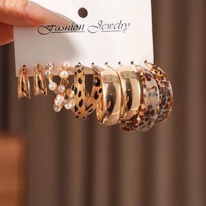 Close-up of leopard print and pearl earrings set with gold-tone metal and resin