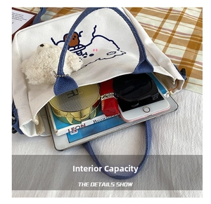 Detail showing white canvas tote interior capacity for phone, cosmetics, and books