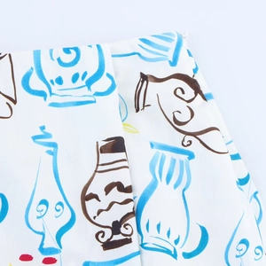 Close-up of white midi skirt fabric with colorful vase print and invisible zipper detail