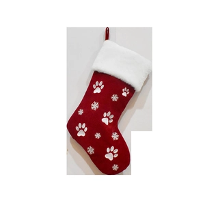 Detail of red velvet Christmas stocking with white plush cuff and embroidered paw prints