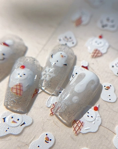 Detailed macro view of 3D embossed snowman and white snowflake nail art stickers
