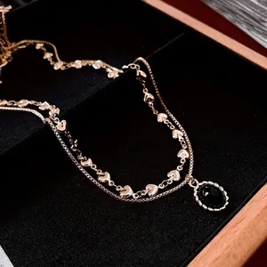 Double-layered gold-plated necklace with heart links and oval black stone pendant