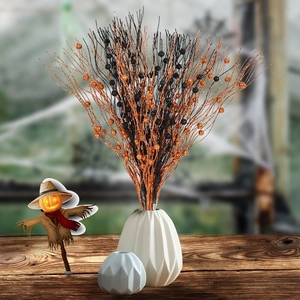 Halloween glitter orange and black decorative branches in white vase with pumpkin decor