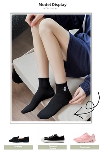 Detailed close-up of ribbed black cotton socks featuring a white cartoon panda embroidery