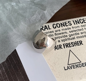 Macro detail of wide teardrop shaped 925 silver ring with high polished smooth metal finish