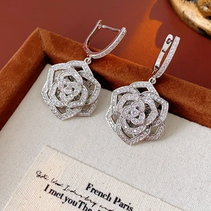 Macro shot of silver hollow rose hoop earrings with micro-set zircon floral petals