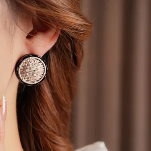 Vintage round enamel stud earrings with champagne gold texture on elegant model