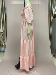 Detail of pink off-shoulder tiered dress with elastic bodice and puffed sleeves