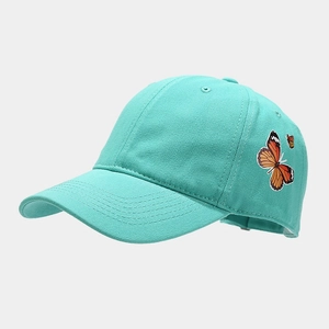 Close-up of vibrant turquoise baseball cap featuring detailed twin butterfly embroidery