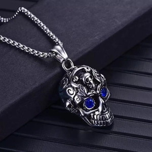 Vintage steel skull necklace with blue gemstone eyes on a silver box chain
