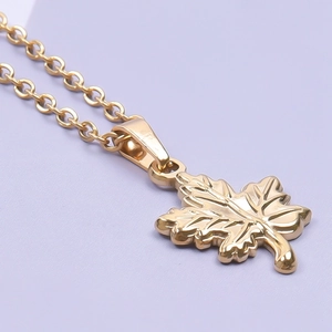 Macro shot of 18k gold plated maple leaf pendant with detailed leaf veins on O-chain