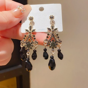 Detailed shot of vintage dark-style tassel earrings featuring black crystals and silver pins