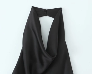 Detail eines schwarzen Satin-Neckholder-Ausschnitts mit elegantem Doppelknopf-Verschluss