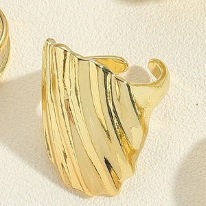 Detail of 14K gold plated ring featuring wide shell-like wavy texture and polished finish