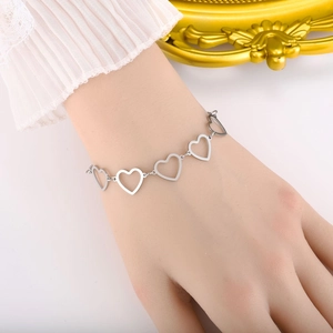 Silver hollow heart-shaped link bracelet in stainless steel on a model's wrist