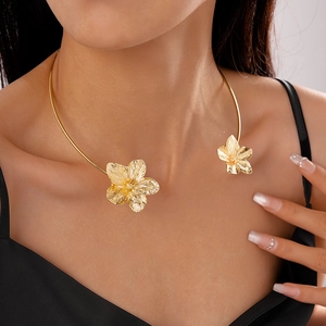 Detailansicht eines goldenen Blumen-Halsreifs mit strukturierten Metallblüten