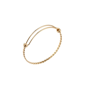 Detail of a golden twisted rope bangle with adjustable open design and spiral texture