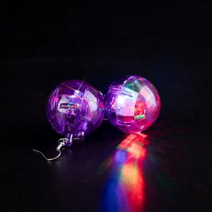 Macro detail of disco ball earrings with internal lights and reflective faceted surfaces