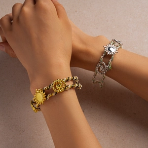 Close-up of woven rope bracelets featuring metallic sunburst and rose flower charms