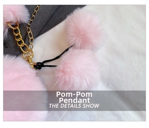 Close-up of fluffy pink faux fur pom-pom charm with gold chain and black cord detail