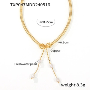 Vue détaillée du collier nœud en cuivre avec glands en perles d'eau douce et fines chaînes