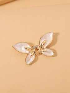 Detail of butterfly earring with gold frame, pearly white wings and tiny diamonds