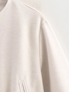 Gros plan d'une veste en laine blanc cassé avec coutures précises et texture daim doux