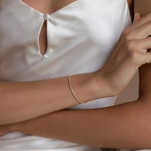 Elegant gold-plated tennis bracelet with shimmering white crystals on female wrist