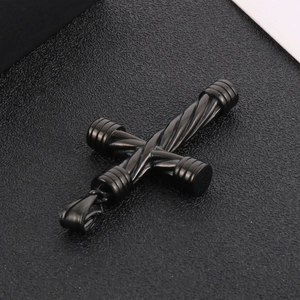 Close-up of black stainless steel cross pendant with twisted texture and metallic finish