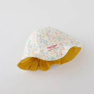 Détail du chapeau de soleil à fleurs pour bébé avec doublure jaune et étiquette tissée