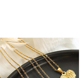 Detail of 18K gold-plated necklace featuring a textured heart pendant on black ceramic