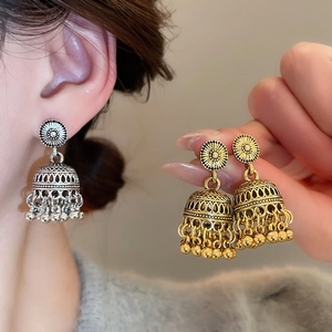 Detail of vintage carved Jhumka bell earrings with beads tassel in gold and silver finish