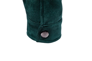 Detail of dark green suede jacket cuff with classic engraved metal snap button