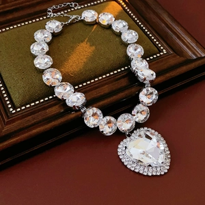 Close-up of a silver heart pendant necklace with shimmering crystals in a velvet box
