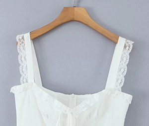 Close-up of white camisole top featuring delicate lace trim and front invisible zipper