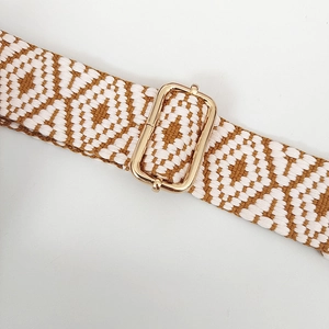 Detail of adjustable woven bag strap with geometric patterns and gold metal buckle