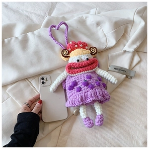Detail of handmade purple crochet doll phone bag with pearls and heart lanyard strap