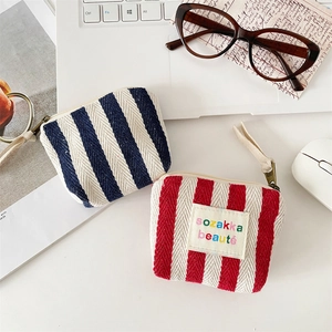 Detailed close-up of striped canvas cosmetic pouch and mini makeup bag with zipper