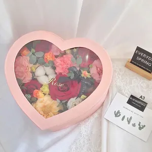 Pink heart-shaped gift box with transparent window and colorful roses for Valentine's Day