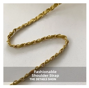 Macro shot of light gold metal chain strap with dense interlocking links and glossy finish