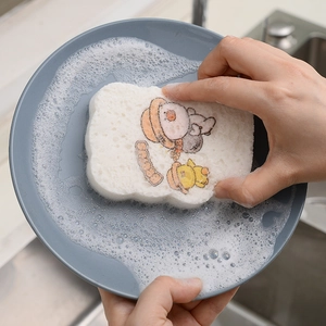 Cartoon duck wood pulp cellulose sponge cleaning a grey plate with rich soapy foam