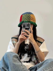 Detailed close-up of handmade multi-color crochet bucket hat with floral knit texture