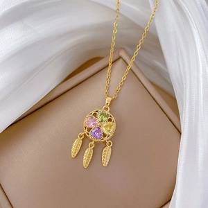 Detailed shot of golden dreamcatcher necklace with colorful heart stones and feather charms