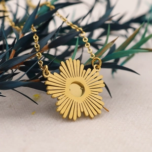 18K vergoldete Halskette mit Sonnenblumen-Anhänger und Naturstein auf Texturhintergrund