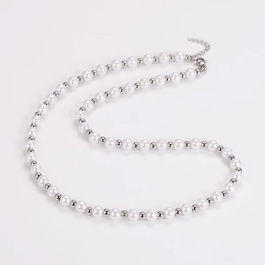 Detailed close-up of white round pearls with silver beads and lobster clasp fastener