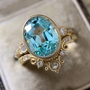 Detailed macro view of vintage gold ring set featuring a large oval blue gemstone